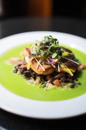 a plate of green soup with beans and greens on it at The Algonquin Hotel Times Square, Autograph Collection in New York