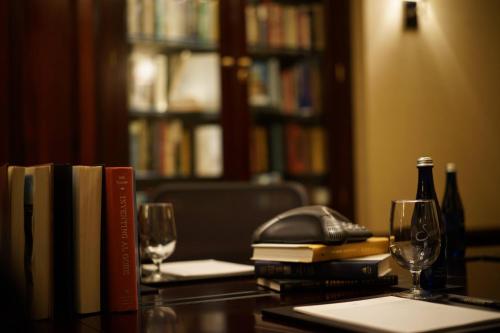 a table with books and wine glasses and a phone at The Algonquin Hotel Times Square, Autograph Collection in New York
