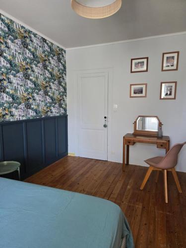 a bedroom with a bed and a table and a chair at Gîte entre Bordeaux et Saint-Emilion in Génissac