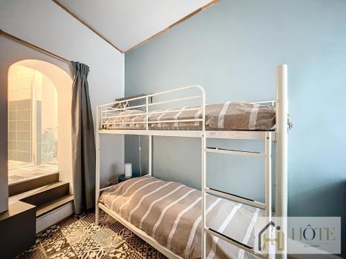 une chambre avec deux lits superposés et une fenêtre dans l'établissement La Petite Malouine - 200m plage, à Dunkerque
