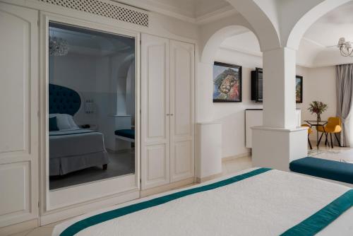a white room with a bedroom with a bed at Hotel Eden Roc in Positano