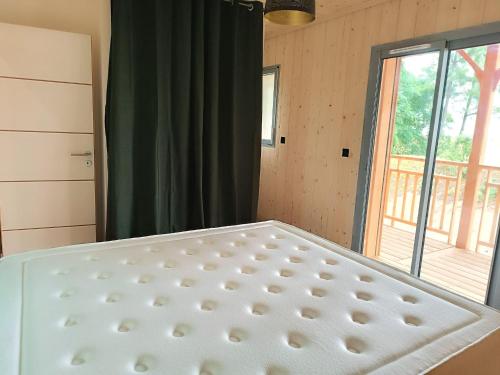 a bed in a room with a window at Maison en bois sur pilotis- 4218 in Le Verdon-sur-Mer