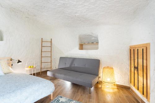 een slaapkamer met een bank, een bed en een ladder bij Home2Book Boutique Cave Retreat, Candelaria in Candelaria