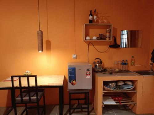 a small kitchen with a table and a small refrigerator at Siem Reap Homesteading in Siem Reap