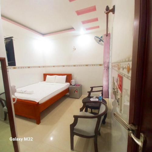 a bedroom with a bed and a table and chairs at Khách sạn Thảo Lợi in Con Dao