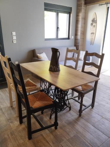 une table en bois avec des chaises et un vase. dans l'établissement Jetez l'ancre, gîte La Tremblade, à La Tremblade