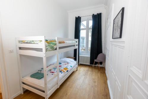Ce lit superposé blanc se trouve dans un dortoir doté d'une fenêtre. dans l'établissement Haussmannien Jaurès, à Troyes
