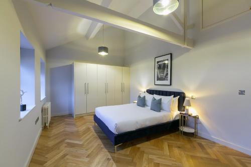 a bedroom with a white bed and wooden floors at Urban Chic - Camden in London