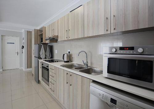 a kitchen with a sink and a microwave at Azure Bliss in Big Bay