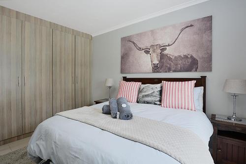a bedroom with a bed with a picture of a cow at Azure Bliss in Big Bay