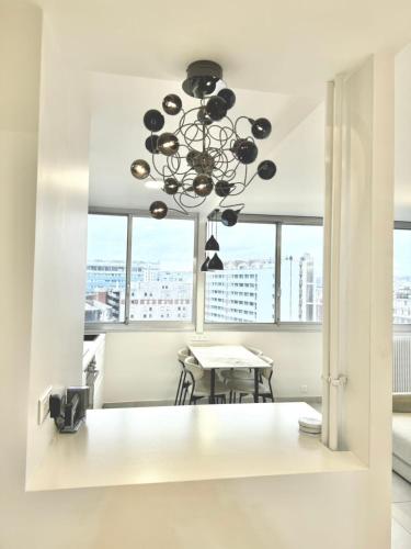 une salle à manger avec un lustre et une table dans l'établissement Modern Parisian flat Quartier asiatique Choisy, à Paris