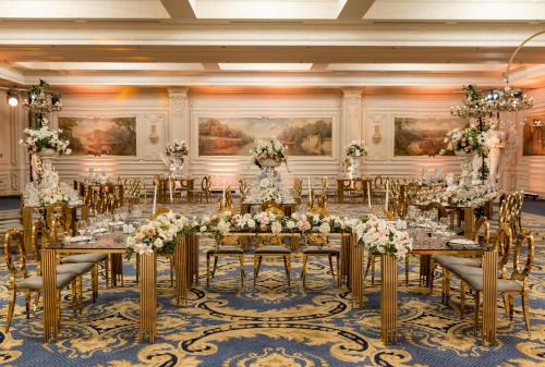 a banquet hall with tables and chairs and flowers at Rixos Montaza Alexandria in Alexandria