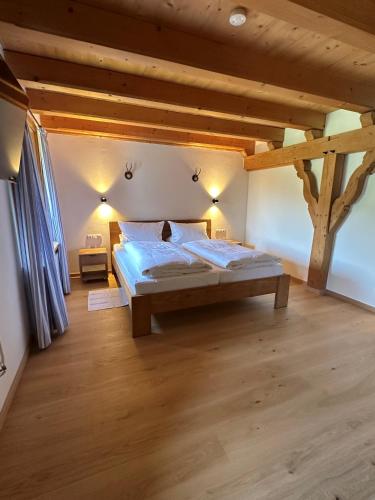 a bedroom with a large bed in a room with wooden ceilings at Ferienwohnung Zum Wunsch in Rottach-Egern