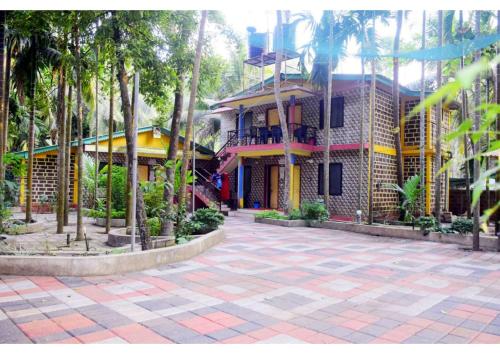 ゴカルナにあるBelaku Farm Houseの前にヤシの木がある建物