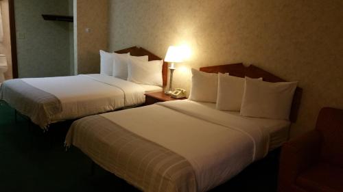 duas camas num quarto de hotel com um telefone numa mesa em Dartmouth Motor Inn em North Dartmouth