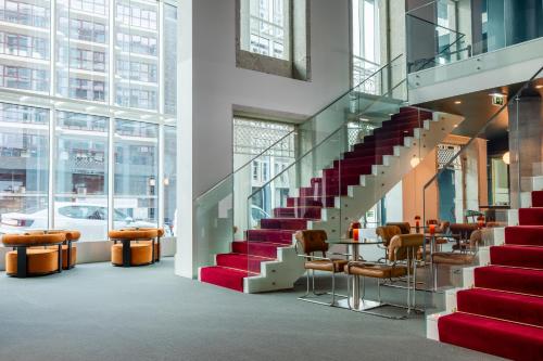 a staircase in a building with chairs and a table at Cenica Porto Hotel, Curio Collection By Hilton in Porto
