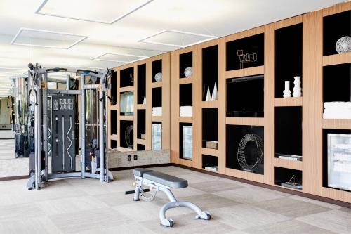 a room with a gym with a bench and equipment at AC Hotel by Marriott Bloomington Mall of America in Bloomington