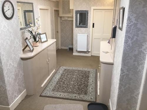 bagno con lavandino e orologio sul muro di Mall House self catering apartment a Montrose