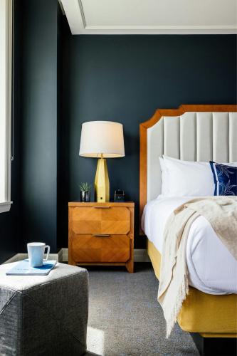 a bedroom with a bed and a table with a lamp at The National, Autograph Collection in Oklahoma City