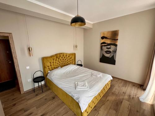 a bedroom with a bed and a painting on the wall at MK Apart Boutique Pipera in Voluntari