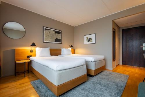 a hotel room with two beds and a mirror at Hyatt Place Gothenburg Central in Gothenburg