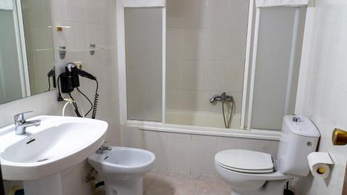 a white bathroom with a sink and a toilet at SunDos Feria Valencia in Valencia