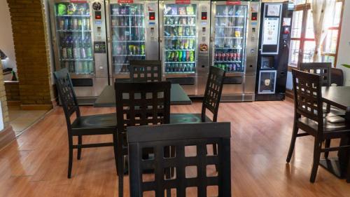 a restaurant with tables and chairs in front of vending machines at SunDos Feria Valencia in Valencia