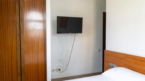 a bedroom with a tv on a wall at SunDos Feria Valencia in Valencia