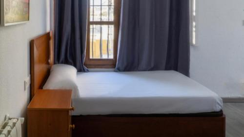 a bedroom with a bed with a window and a table at SunDos Feria Valencia in Valencia