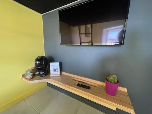 a mirror hanging on a wall above a wooden shelf at Studio du faubourg in Valence