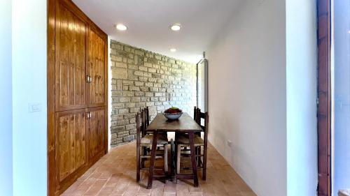 a dining room with a table and chairs and a brick wall at Villa Le Fate - idromassaggio in Sambuco