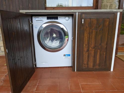 a washer and dryer sitting next to a wooden door at Villa Le Fate - idromassaggio in Sambuco