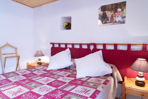 - une chambre avec un lit rouge et des oreillers blancs dans l'établissement L'oustal de julie 3 personnes, à Laval-du-Tarn