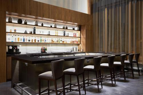 a bar with a row of bar stools at AC Hotel by Marriott Madison Downtown in Madison