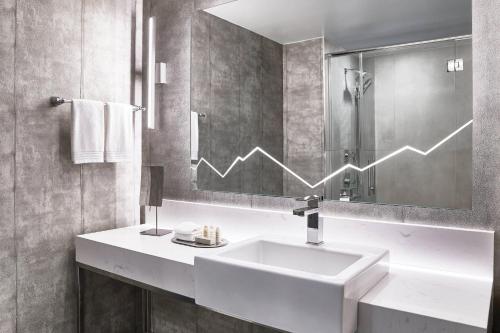 a bathroom with a sink and a graph on the mirror at Renaissance Denver Hotel & Conference Center in Denver