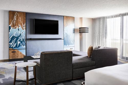 a living room with a couch and a tv at Renaissance Denver Hotel & Conference Center in Denver