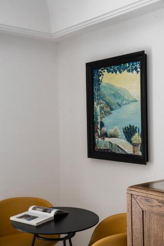 a painting hanging on a wall with a table at Hotel Eden Roc in Positano