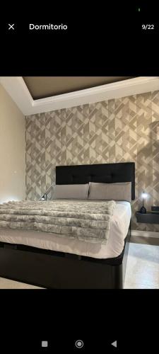 a bedroom with a large bed with a wall at Apartamento ideal en calle florista in Valencia