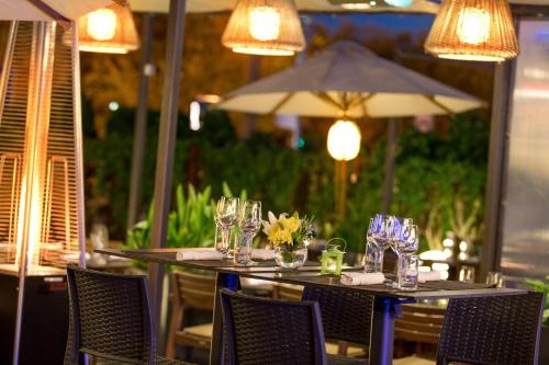 a table with glasses and flowers on top at Renaissance by Crystall in Atyraū