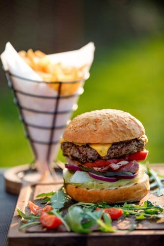 a hamburger on a table with a basket of fries at Renaissance by Crystall in Atyraū