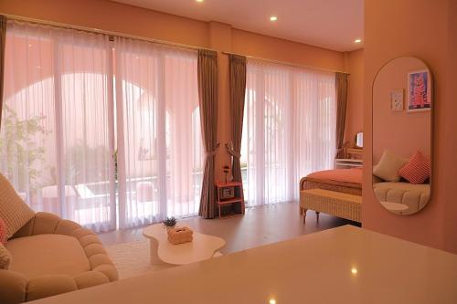 a living room with a bed and a large window at Ponder Bali Canggu in Canggu