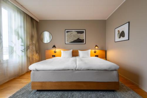 a bedroom with a bed with two lamps and a window at Hyatt Place Gothenburg Central in Gothenburg