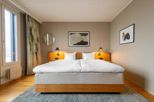 a bedroom with a large white bed with two lamps at Hyatt Place Gothenburg Central in Gothenburg