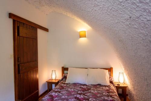 une chambre avec un lit avec deux lampes sur deux tables dans l'établissement Aux cimes des gorges du tarn, à Laval-du-Tarn