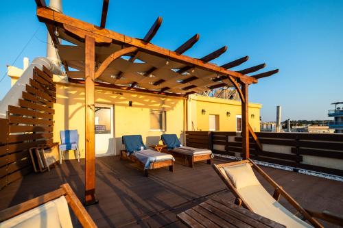 a rooftop deck with chairs and a wooden pergola at Vento di Mare in Perea