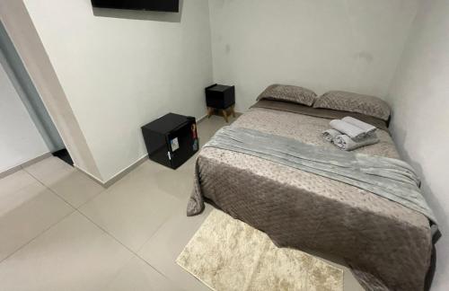 a bedroom with a bed with two towels on it at Caverna Suítes - Suítes na praça matriz in São Thomé das Letras
