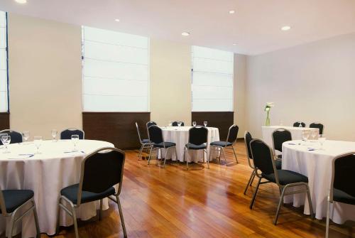 a room with tables and chairs with white table cloth at NH Mendoza Cordillera in Mendoza
