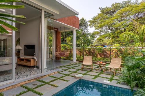 a house with a swimming pool and a patio at La Masillia, 2 BHK with Private Pool, 15 mins from Morjim Beach, Wifi, Peaceful location, Kitchen, Security, Patio in Siolim