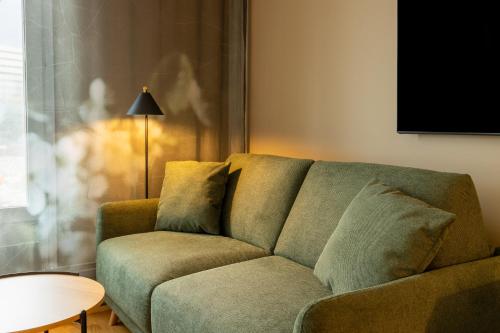 a couch in a living room with a table and a lamp at Hyatt Place Gothenburg Central in Gothenburg