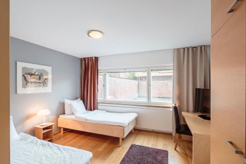 a hotel room with a bed and a window at Hotel Rantapuisto in Helsinki